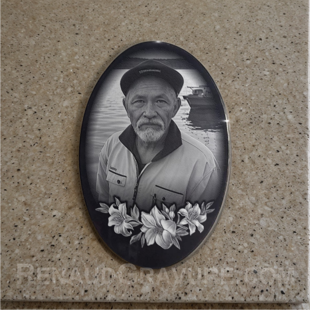 Plaque funeraire ovale en granit avec fleurs et portrait gravé.